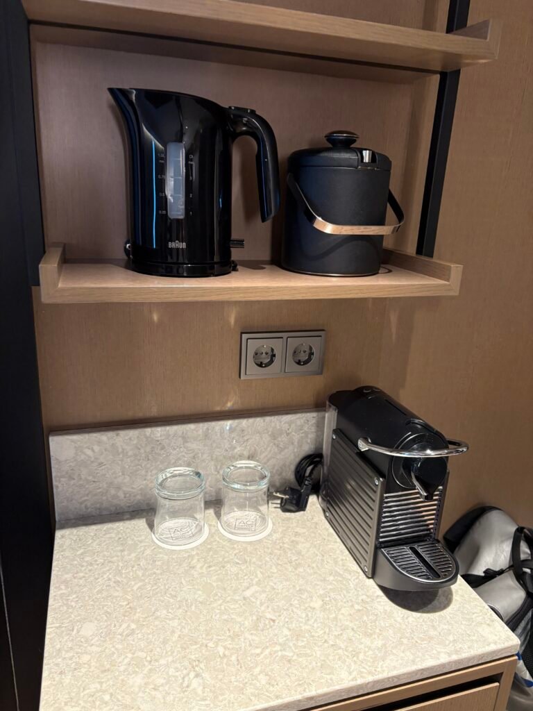 Nespresso machine, electric kettle, glasses and bottled water in an AC Hotel Seoul Gangnam guest room