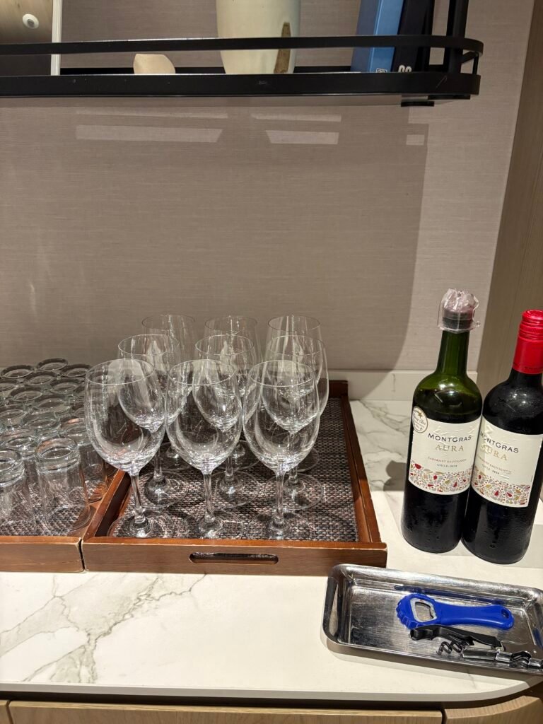 Wine bottles and rows of glasses during Premier Lounge happy hour