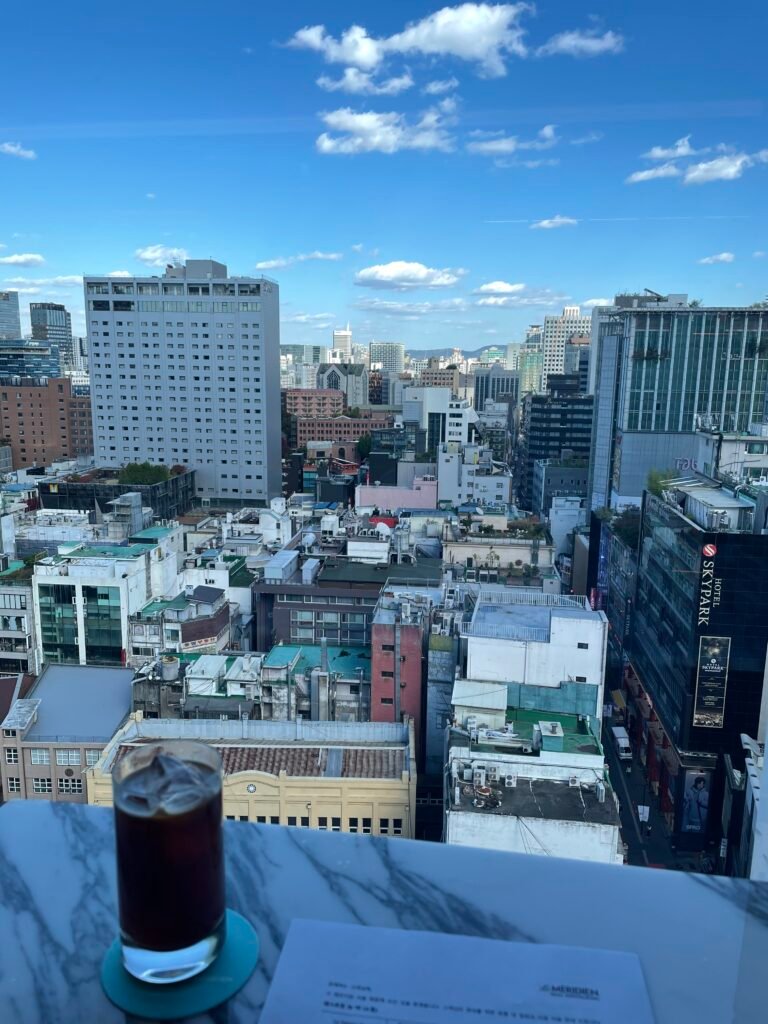 Drink beside a Club Lounge window overlooking central Myeongdong