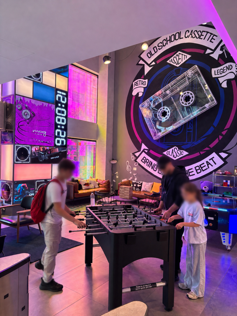 Guests playing foosball in the colorful Play Moxy social lounge
