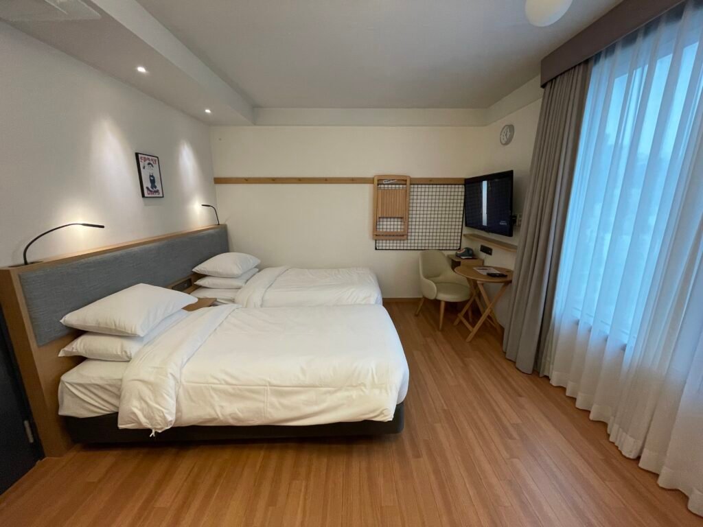 Compact guest room with two twin beds at Moxy Seoul Insadong