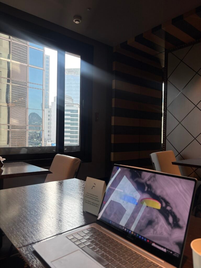 Laptop on a table in THE PLAZA Seoul club lounge with a daytime city view