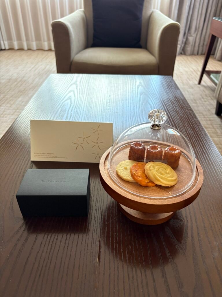 Birthday cookies, welcome snacks, and a handwritten card on a table in the suite