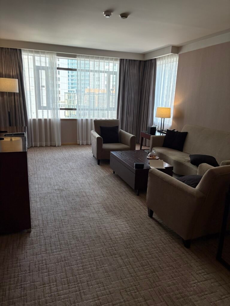 Living room with a large sofa and windows in the Executive Suite at The Westin Josun Seoul