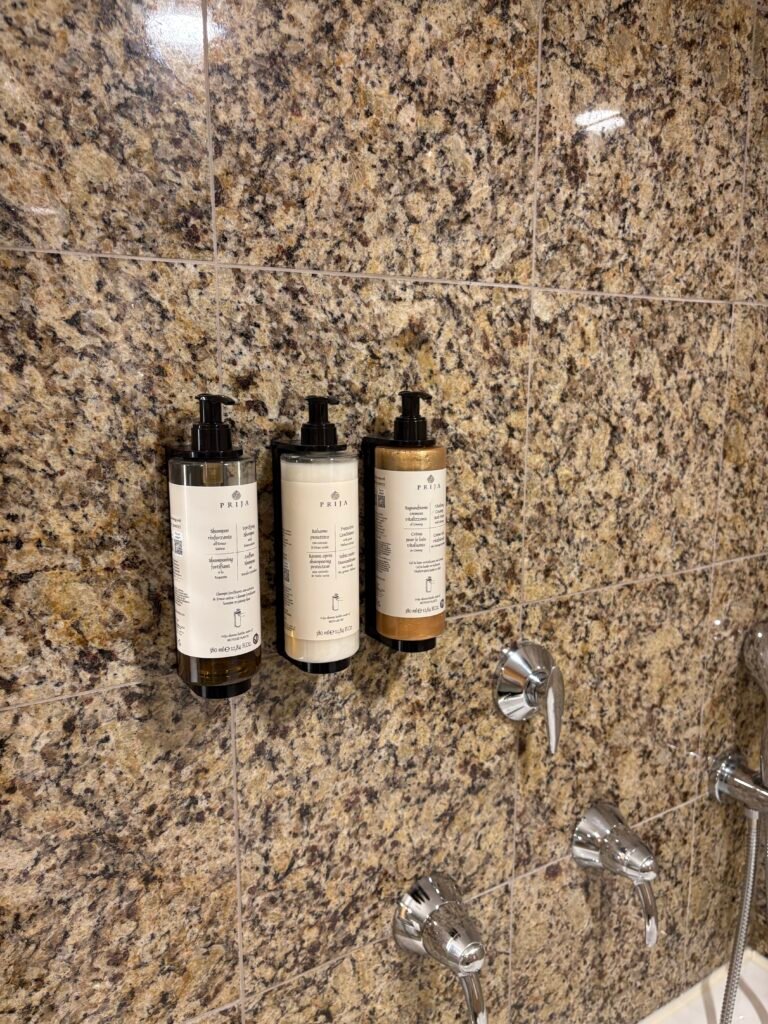 Reusable bottles of Prija bath products on the bathroom counter