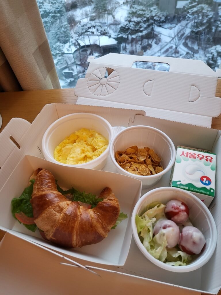 Takeaway breakfast box with croissant sandwich, salad and fruit at Aloft Seoul Gangnam