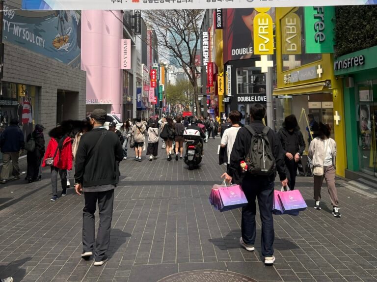 Busy shopping street in Myeongdong, Seoul, with pedestrians, shops and multilingual signs
