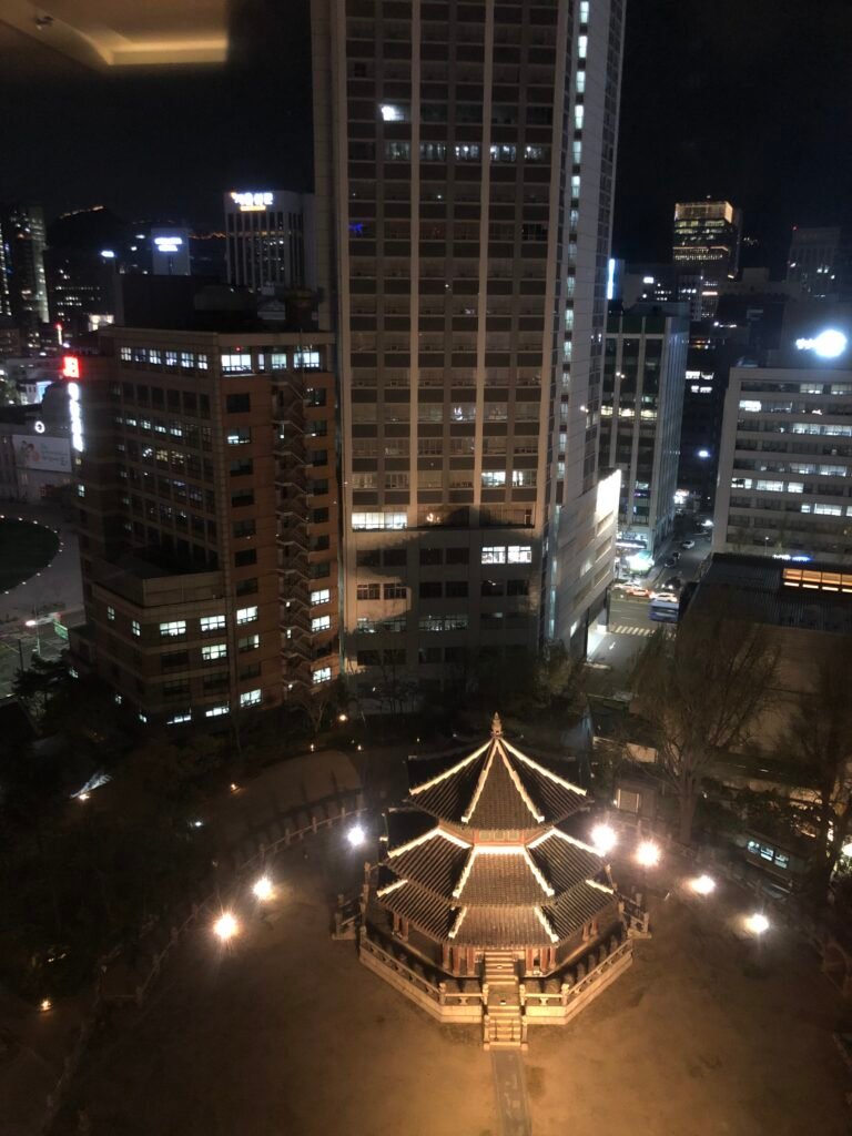 Hwangudan illuminated at night beside The Westin Josun Seoul
